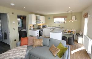 a living room with a couch and a kitchen at The Wren in Whitchurch