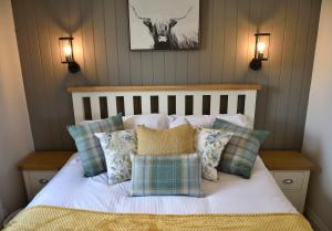 a bedroom with a bed with pillows and a cow on the wall at The Wren in Whitchurch