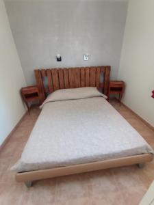 - une chambre avec un lit et une tête de lit en bois dans l'établissement villa bana, à Patrimonio