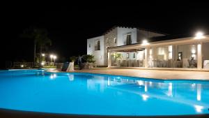 uma piscina em frente a uma casa à noite em La Corte del Sole em Calatafimi