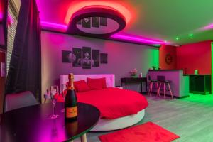 a bedroom with a red bed and a bottle of wine at Secret Night in Toulouse