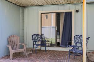 un gruppo di sedie seduti su un portico di Coastal Waters a New Smyrna Beach