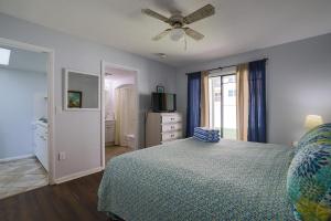 a bedroom with a bed and a ceiling fan at Coastal Waters in New Smyrna Beach