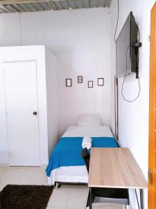 ein kleines Schlafzimmer mit einem Bett und einem Holztisch in der Unterkunft Habitación en la playa in Tumbes