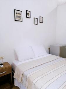 a white bedroom with a bed and a table at Habitación en la playa in Tumbes