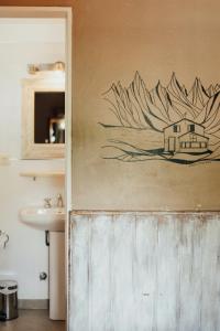 a bathroom with a painting of a house on the wall at Selva India Suites in San Carlos de Bariloche +22 photos