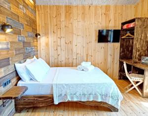 um quarto com uma cama e uma parede de madeira em kartalia wooden studios em Porto Koufo