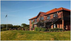 a large brick building with a picnic table in front of it at Hunley Golf Club in Saltburn-by-the-Sea