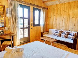 a living room with a couch and a window at kartalia wooden studios in Porto Koufo