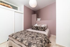 - une chambre avec un lit dans une pièce aux murs violets dans l'établissement plage st jean RESIDENCE LE GOLFE D AZUR, à La Ciotat