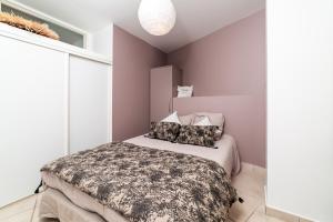 a bedroom with a bed in a room with purple walls at plage st jean RESIDENCE LE GOLFE D AZUR in La Ciotat