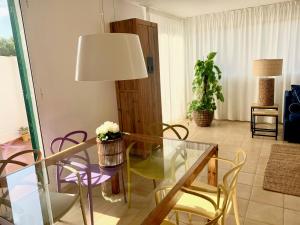 a living room with a glass table and chairs at Es Cucó in Cala Galdana