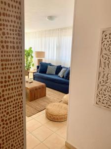 a living room with a blue couch and a table at Es Cucó in Cala Galdana