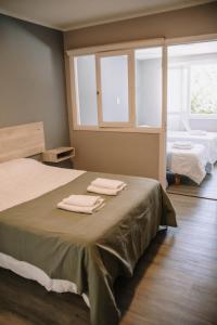 une chambre avec un lit avec deux serviettes dessus dans l'établissement Hotel Aires Patagónicos, à El Bolsón