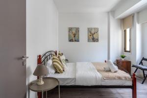 um quarto branco com uma cama e uma mesa em Eleni’s 1-BR Apt in Larnaca Center em Lárnaca