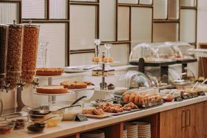 una línea de buffet con bollería y otros productos alimenticios en Mera Hotel, en Budapest