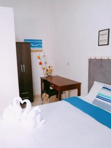 a bedroom with a bed and a desk with a swan at Vista Palmeras in Zorritos