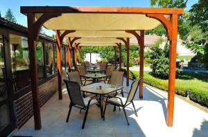 a pavilion with tables and chairs on a patio at Pensiunea Eden Caransebes in Caransebeş