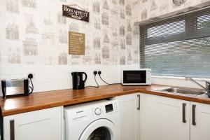 a kitchen with a washing machine and a sink at Alexander Apartments Durham in Chester-le-Street