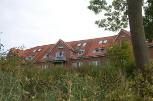 un bâtiment en briques rouges avec un arbre devant lui dans l'établissement Ferienwohnung mit Ostseeblick in Rerik, à Rerik