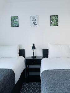 two beds sitting next to each other in a room at Cheerful 5-bedroom with free parking in Bristol