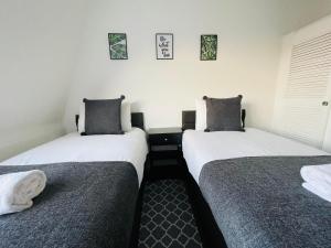 two beds sitting next to each other in a room at Cheerful 5-bedroom with free parking in Bristol