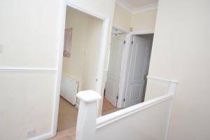 a white hallway with a mirror and a door at London Deluxe 3 Bedroom House with parking space in Dagenham +20 photos