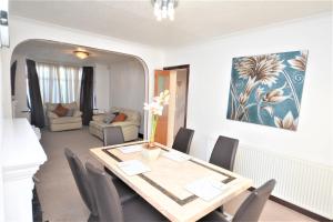a dining room with a table and chairs at London Deluxe 3 Bedroom House with parking space in Dagenham