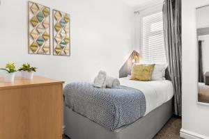 a bedroom with a bed and a desk and a window at Rock Terrace Accommodation - TV in Every Bedroom! in Morriston