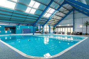 a large swimming pool with blue walls and ceilings at Spindrift in Rendham