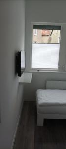a small bedroom with a bed and a window at Detmold City Premium Appartement H17 in Detmold