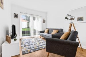 a living room with a couch and a tv at Clase Accommodation - TV in Every Bedroom! in Morriston