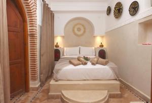 ein Schlafzimmer mit einem weißen Bett mit zwei Teddybären darauf in der Unterkunft Riad Venezia in Marrakesch