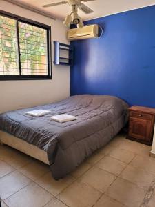 1 dormitorio azul con 1 cama con 2 toallas en Casa Balcarce en Godoy Cruz