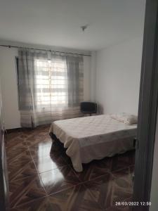 1 dormitorio con 1 cama y 1 silla en Hermoso apartaestudio, en Pitalito
