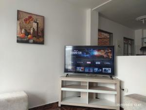 a flat screen tv sitting on a stand in a living room at Hermoso apartaestudio in Pitalito