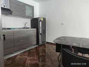 a kitchen with a table and a refrigerator at Hermoso apartaestudio in Pitalito