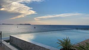 a swimming pool with a view of the ocean at Can Salia in San Antonio Bay