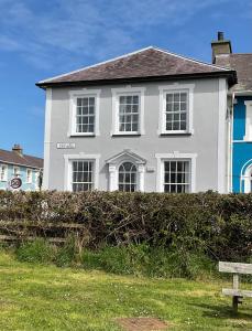 a white house with a bench in front of it at 2 Yr Hen Fanc in Aberaeron