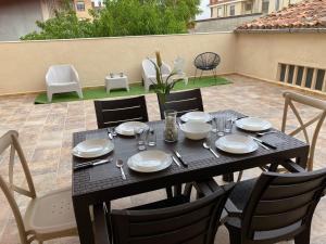 a table with plates and utensils on a patio at Casa Melodía in Calahorra