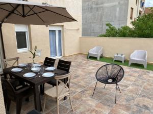 stół z krzesłami i parasol na patio w obiekcie Casa Melodía w mieście Calahorra