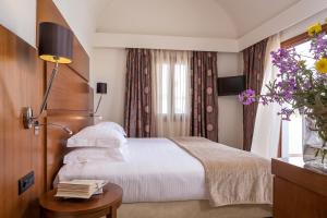 Postel nebo postele na pokoji v ubytování Theoxenia Caldera Hotel