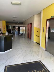 een lege lobby met gele en gele muren en een deur bij Oft Neve's hotel in Goiânia
