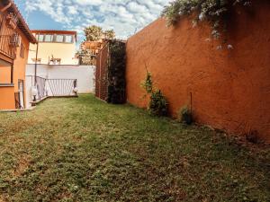 une cour à côté d'un mur de briques avec une clôture dans l'établissement Renella 92, à Rome