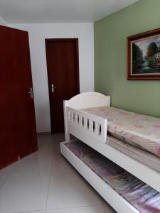 ein Schlafzimmer mit zwei Betten und einem Bild an der Wand in der Unterkunft GUARUJÁ ENSEADA CASA 6 PES PROX PRAIA in Guarujá