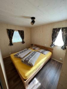a bedroom with a bed in a tiny house at Bungalow Miralago in Camping Cavresc, Via dal Cavresc 1, 7746 Le Prese-Poschiavo in Poschiavo