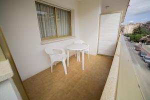 a white table and chairs on a balcony at Apartamentos Eldorado in Lloret de Mar