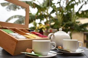 due tazze di caffè su un tavolo con una scatola di legno di Gawhra B&B a Victoria Altre 31 foto