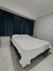 a large white bed in a bedroom with a wall at Hotel Kasvel in Valledupar