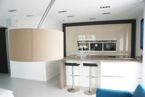 a kitchen with a island with stools and a large light fixture at Appart'Hôtel Luxapparts in Besançon